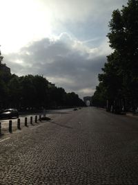 Empty road with trees in background