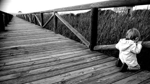 Rear view of woman on wooden footbridge