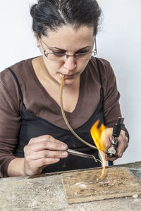 Woman using flamethrower while making jewelry