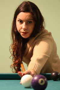 Portrait of young woman holding ball while sitting on table