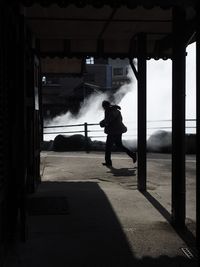Rear view of silhouette man standing in bus