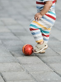 Low section of boy playing with toy on road