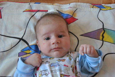 Portrait of cute baby lying on bed