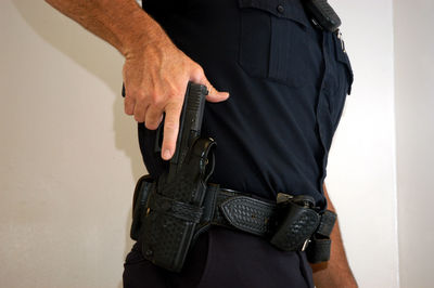 Midsection of man holding gun