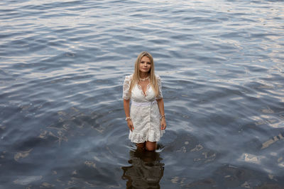 Portrait of young woman standing in water
