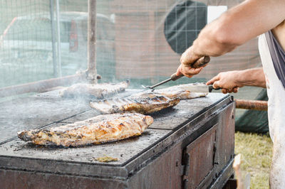 Man preparing meat on barbecue grill