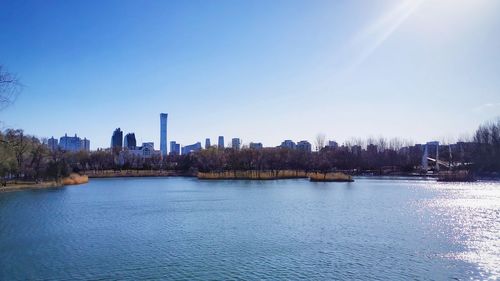 Scenic view of river by city against sky