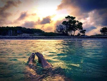 Scenic view of sea against cloudy sky at sunset