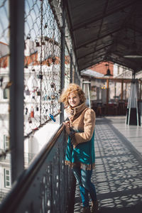 Portrait of woman standing by railing 