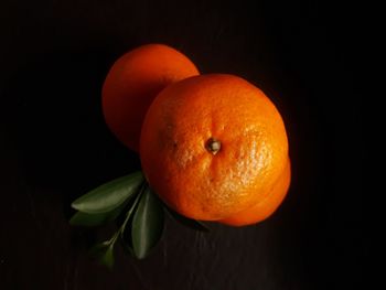 Close-up of orange apple against black background