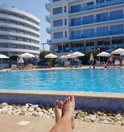 Low section of man relaxing in swimming pool