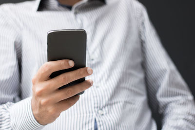 Midsection of man using mobile phone