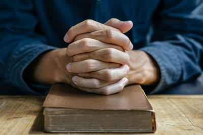 Close-up of man holding stack on table