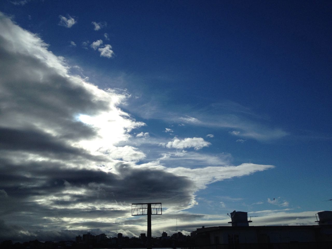 sky, low angle view, cloud - sky, blue, silhouette, cloud, built structure, cloudy, architecture, nature, beauty in nature, building exterior, outdoors, no people, tranquility, scenics, day, sunlight, street light, high section