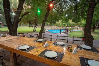 Empty chairs and table against trees