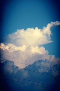 Low angle view of power lines against blue sky