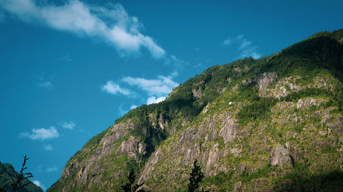 Low angle view of mountain against blue sky