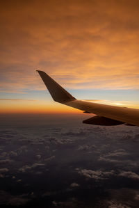 Airplane flying over cloudscape during sunset