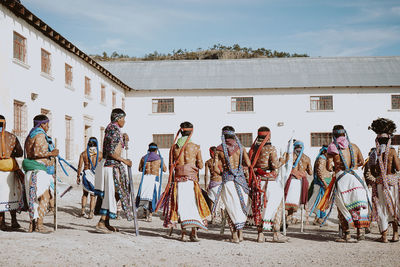 People standing outside building against sky