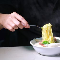 Close-up of hand holding bowl of table