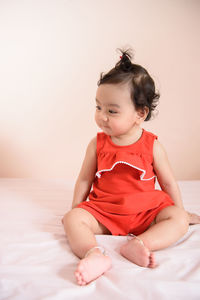 Cute baby girl sitting on bed