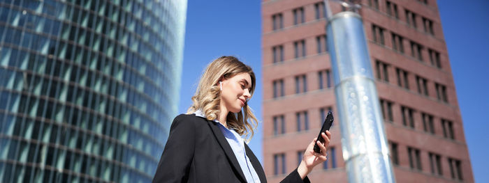 Low angle view of businessman standing against modern building