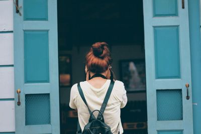 Rear view of woman standing against building