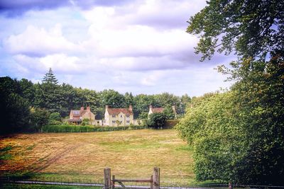 View of field against cloudy sky