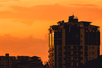 Low angle view of buildings against sky during sunset