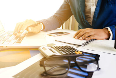 Midsection of man using laptop on table