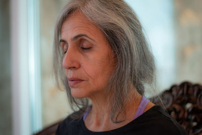 Close-up of senior woman with eyes closed at home