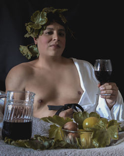 Portrait of man drinking glasses on table