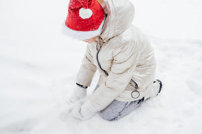 High angle view of girl playing on snow