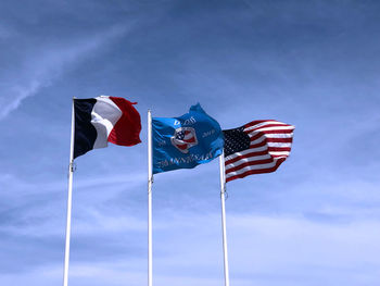 Low angle view of flag flags against blue sky