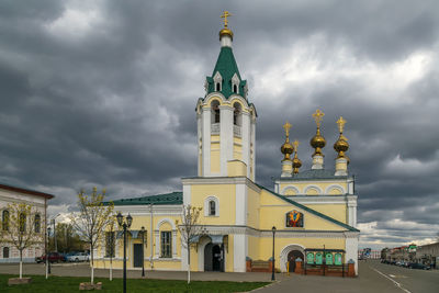 View of buildings in city against cloudy sky