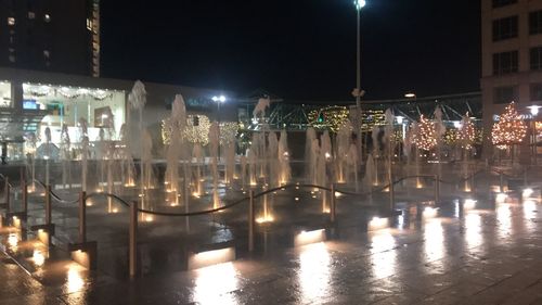 Illuminated buildings by street at night