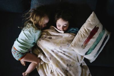 High angle view of mother and daughter on bed