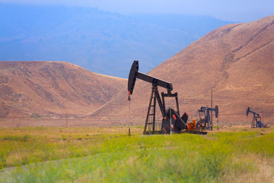 Machinery on land against mountain range