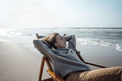 Young woman relaxing on chair at beach