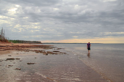 Man standing on beach against sky
