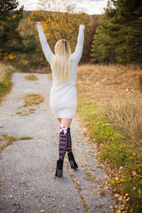 Low section of woman standing on field