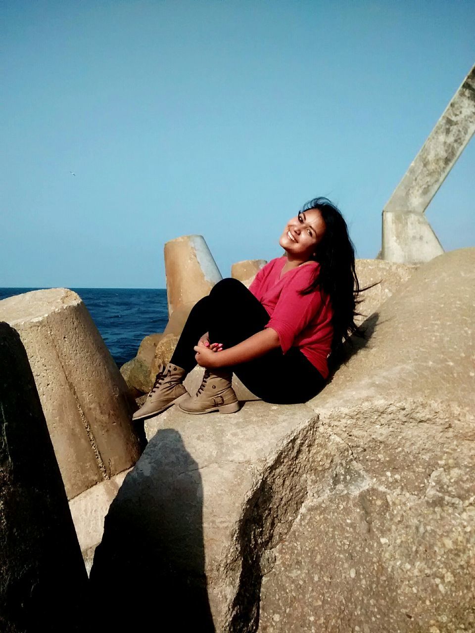 lifestyles, leisure activity, casual clothing, water, person, young adult, full length, sea, standing, young women, clear sky, beach, built structure, sunglasses, photography themes, technology, sky, horizon over water