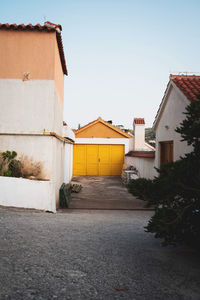 Houses by street against sky in city