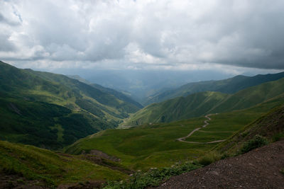 Scenic view of valley and mountains against sky