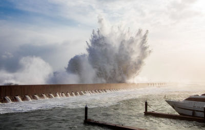 Scenic view of sea against cloudy sky, waves crashing during massive winter storm. 