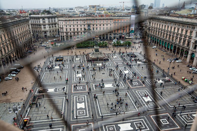 Crowd at piazza del duomo seen through window