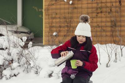 Girl pouring drink from thermos