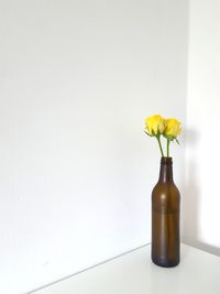 Close-up of yellow flowers in vase on table