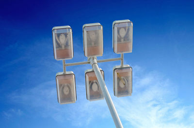 Low angle view of telephone pole against blue sky