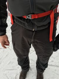 Low section of man standing on sand